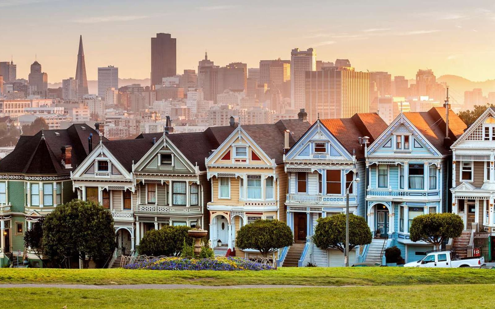 San Francisco’s Painted Ladies at sunset, with the city skyline behind them